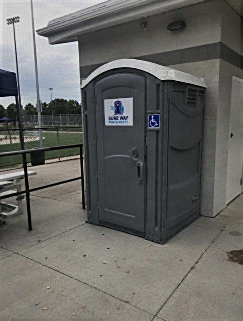 ADA-compliant porta potty rental unit with wide door and ground-level entry in Holland, MI