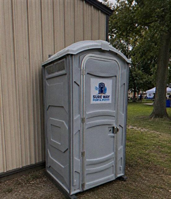 Deluxe flushing Sure Way Porta Potty rental unit with sink, set up for an event